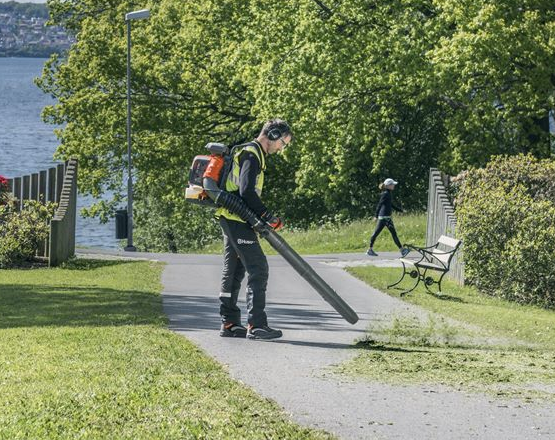 man operating backpack leaf blower in park