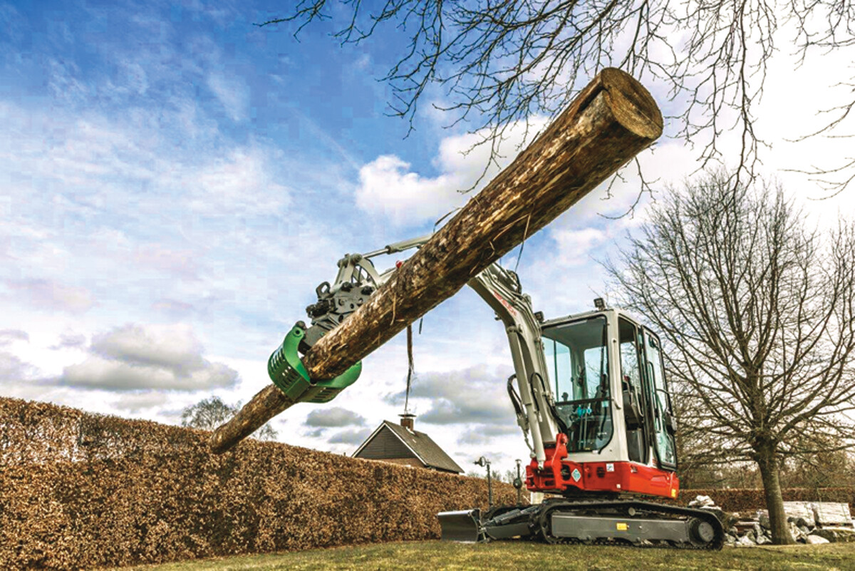 Takeuchi excavator lifting huge tree log